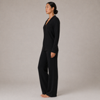 Model wearing the FitFigura Soft LoungeWear Set – Comfort Form in Onyx Black, shown from the side with a long-sleeve top and relaxed lounge pants.