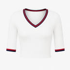 Flat lay of the white Fitfigura Ace Set – Signature Court Form top, featuring a V-neckline with contrast trim and short sleeves.
