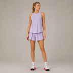 Model wearing the Fitfigura Ace Top – Sculpt Tank Form in light purple with a matching skirt, white socks, and pink-accent shoes, shown from the front.