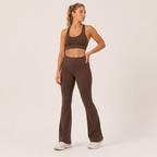 Model wearing the Fitfigura Balance Flare Pant – Sculpt Silhouette in brown with a matching brown sports bra, shown from the front.