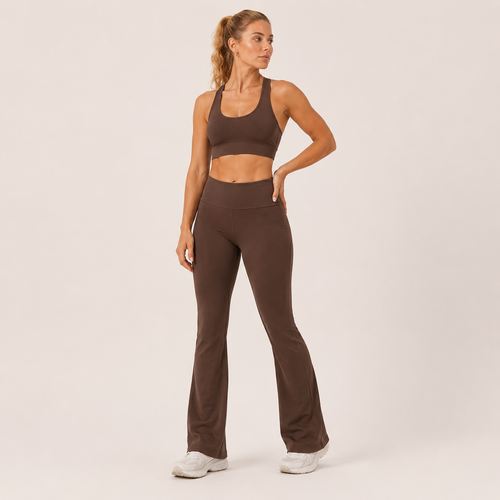 Model wearing the Fitfigura Balance Flare Pant – Sculpt Silhouette in brown with a matching brown sports bra, shown from the front.