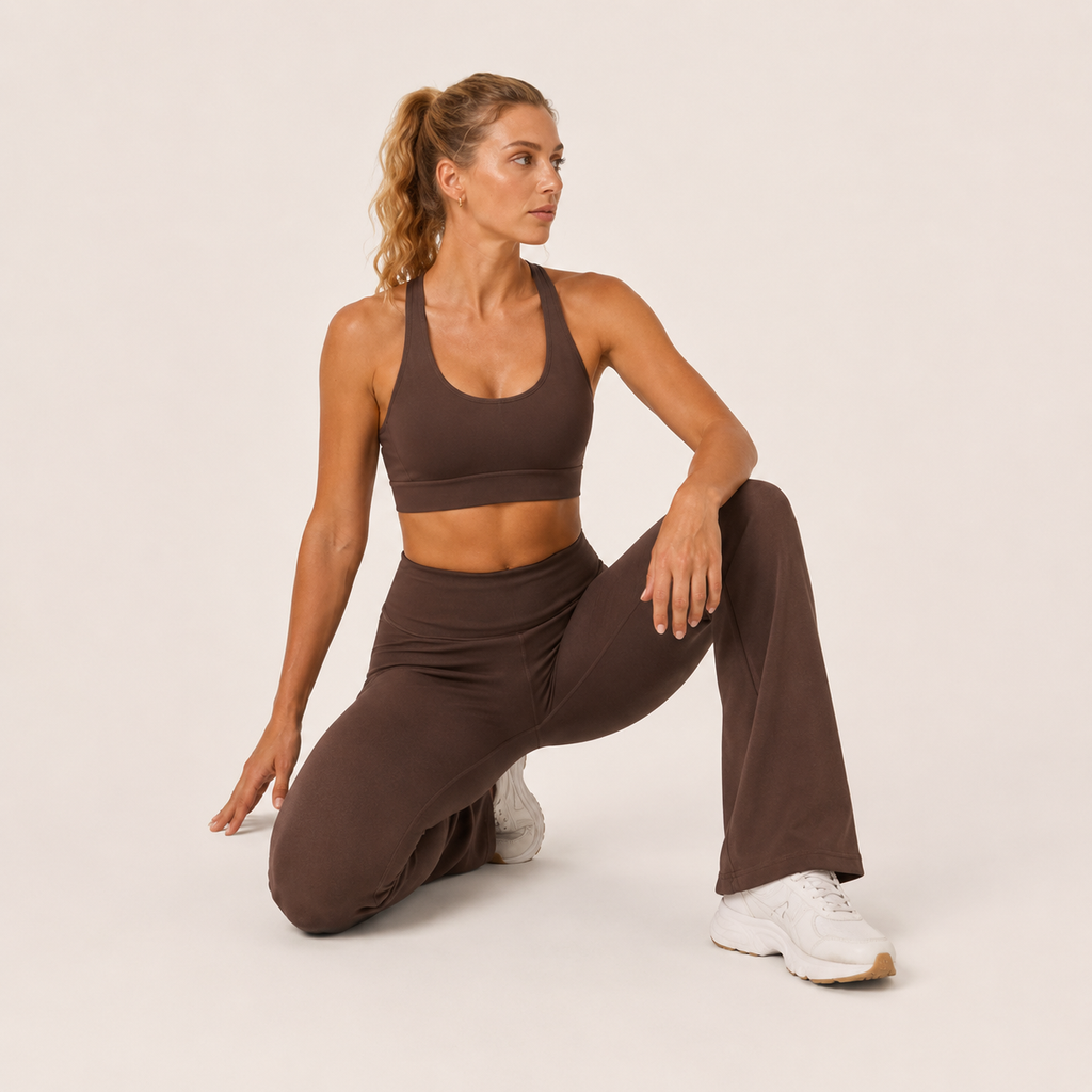 Model seated in the brown Fitfigura Balance Flare Pant – Sculpt Silhouette, showing the soft stretch fit and flared shape.