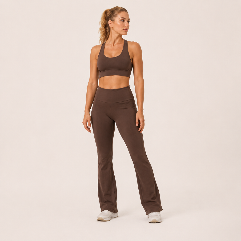 Full-body view of the brown Fitfigura Balance Flare Pant – Sculpt Silhouette, styled with a matching sports bra and white sneakers.