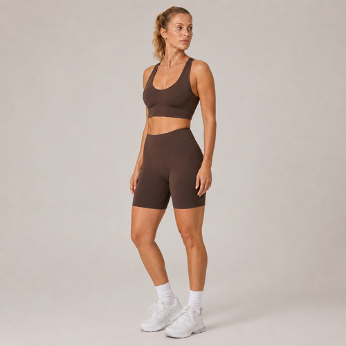 Full-body studio view of the dark brown Fitfigura Contour Bra – Defined Sculpt, styled with matching shorts and white sneakers.