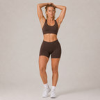 Model wearing the dark brown Fitfigura Contour Bra – Defined Sculpt with arms raised, highlighting the secure fit and sculpted activewear shape.
