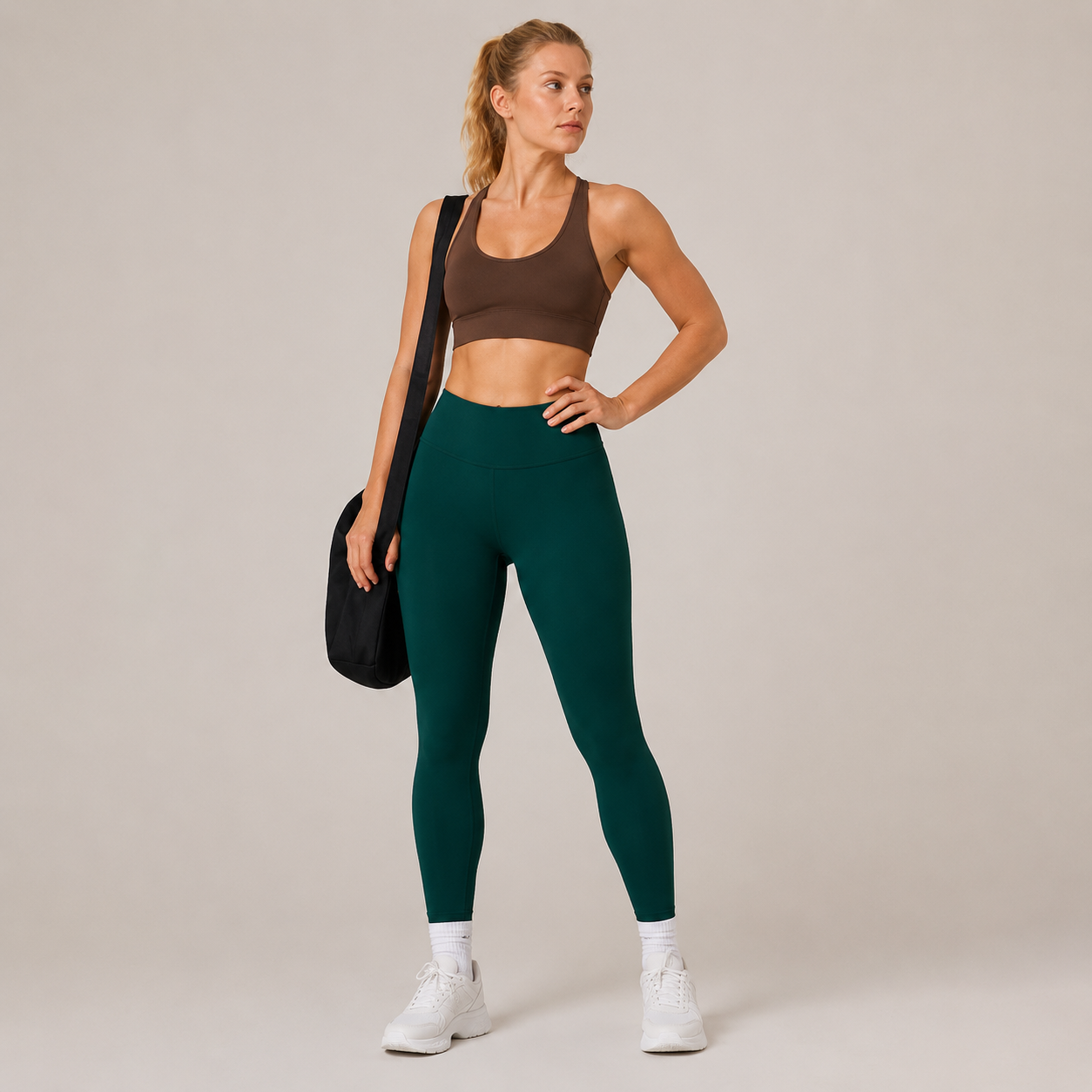 Model wearing the Fitfigura Core Compression Legging in deep teal with a brown sports bra, white socks, and a black gym bag, shown from the front.