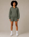 Model wearing the Fitfigura Core Hoodie – Essential Form in olive green with matching shorts and white socks, shown from the front.