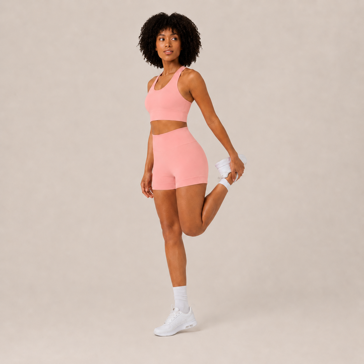 Angled studio view of the coral pink Fitfigura Core Set – Minimal Sculpt Form, highlighting the clean crop top and matching skirt design.