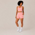 Rear-angle studio view of the coral pink Fitfigura Core Set – Minimal Sculpt Form, showing the coordinated top and skirt silhouette.