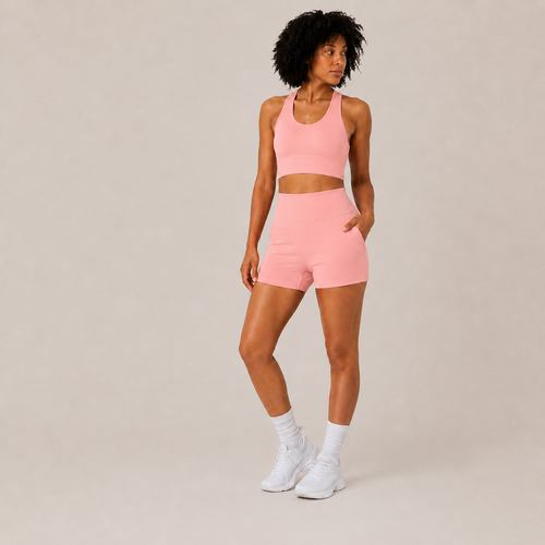Rear-angle studio view of the coral pink Fitfigura Core Set – Minimal Sculpt Form, showing the coordinated top and skirt silhouette.