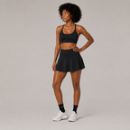 Angled studio view of the black Fitfigura Court Skirt – Classic Elite Form, showing the coordinated court-ready look and flared skirt shape.