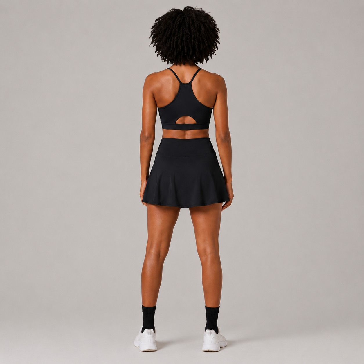 Back view of the Fitfigura Court Skirt – Classic Elite Form in black, showing the rear fit of the skirt and matching sports bra.