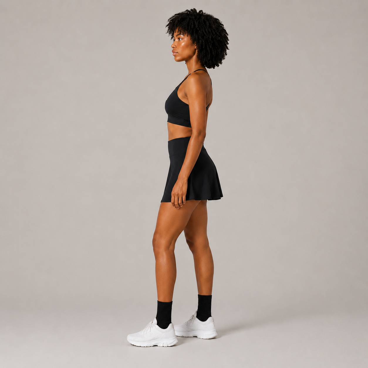 Side profile of the black Fitfigura Court Skirt – Classic Elite Form, highlighting the skirt silhouette and athletic fit.