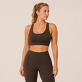 Model wearing the Fitfigura Crossback Bra – Sculpt Line in dark brown with matching leggings, showing the scoop neckline and supportive fit.