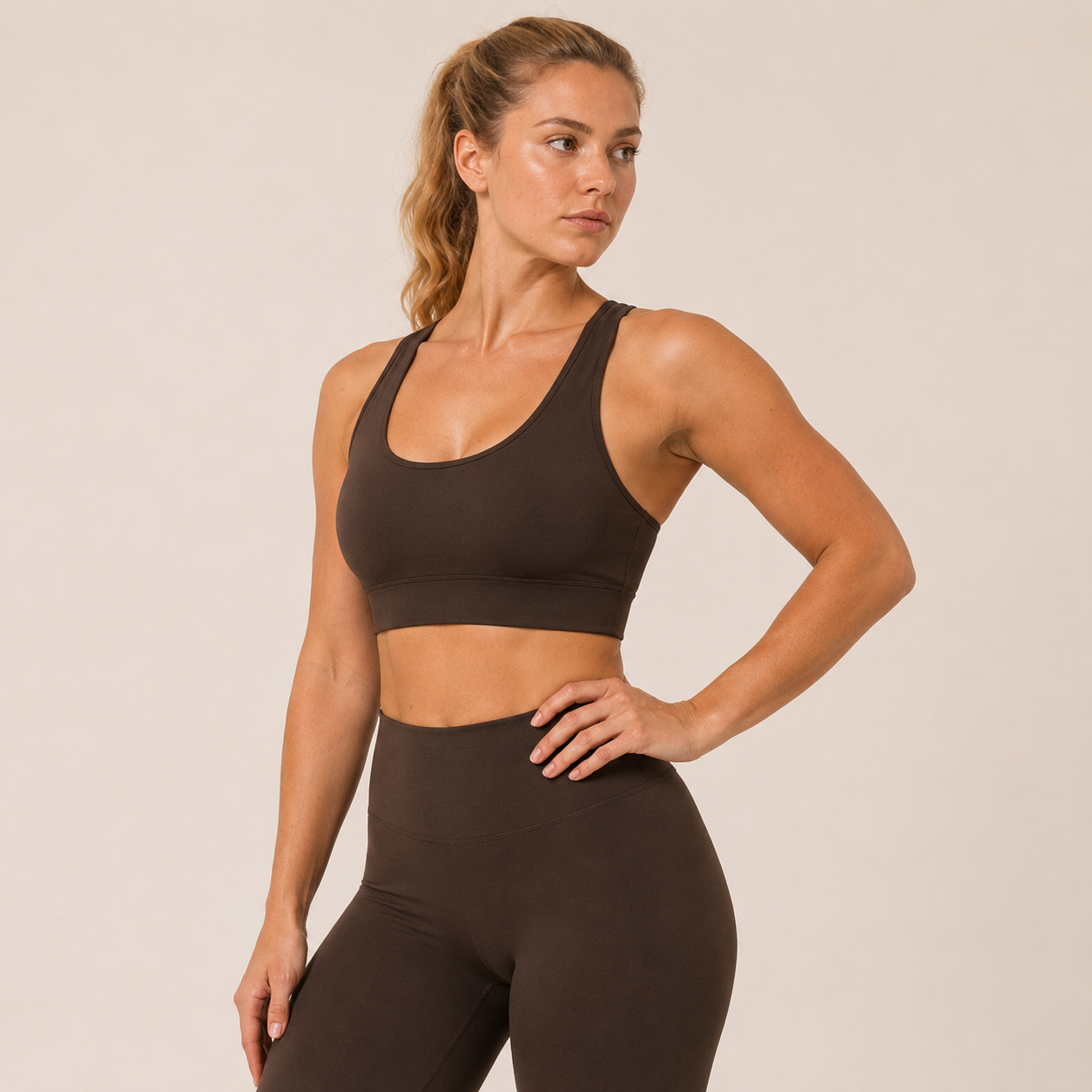 Model posing in the Fitfigura Crossback Bra – Sculpt Line in dark brown, paired with matching leggings for a coordinated activewear look.