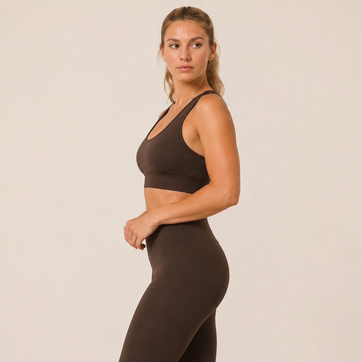 Side view of the dark brown Fitfigura Crossback Bra – Sculpt Line, highlighting the cropped sports bra shape and smooth sculpted fit.