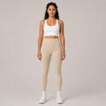 Model wearing the Fitfigura Flex Rib Legging in cream with a white crop top and white socks, shown from the front.