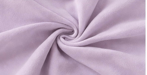 Close-up of the soft light purple fabric texture used in the Fitfigura Flow Performing Set – Soft Movement Form.