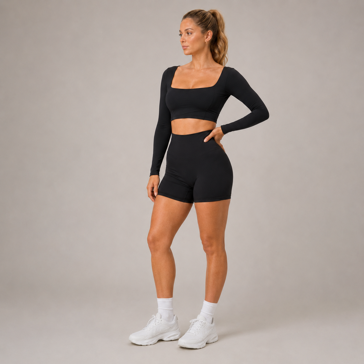 Model posing in the black Fitfigura Freedom Scoop Long Sleeve Crop Top with matching shorts, highlighting the scoop neckline and active fit.