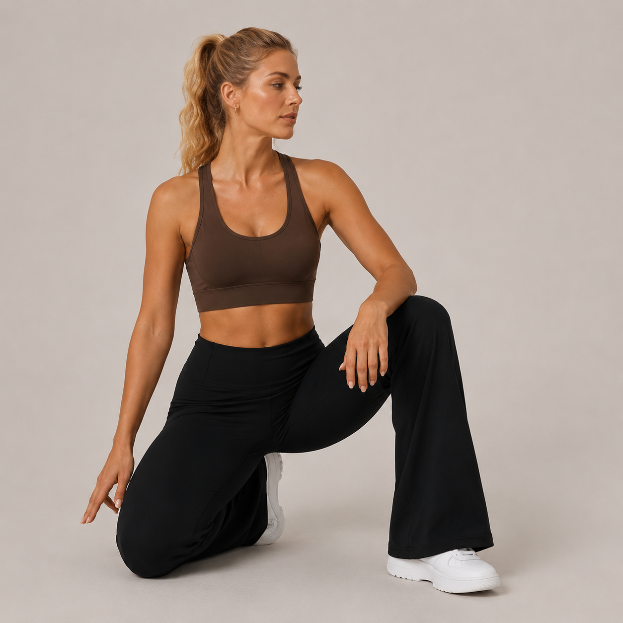 Model seated in the black Fitfigura Lounge Flare Pant – Relaxed Luxury Form, showing the soft stretch fit and relaxed flared shape.