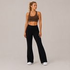 Full-body studio view of the black Fitfigura Lounge Flare Pant – Relaxed Luxury Form, styled with a brown activewear top and white sneakers.