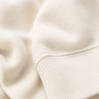 Close-up of the soft ivory fabric texture and ribbed trim used in the Fitfigura Lounge Oversized Hoodie – Soft Form.