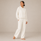 Side-angle view of the ivory Lounge Oversized Hoodie – Soft Form styled with matching wide-leg pants.