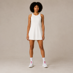 Model wearing the Fitfigura Match Dress – Sculpt Motion Form in white with white socks and sneakers, shown from the front.