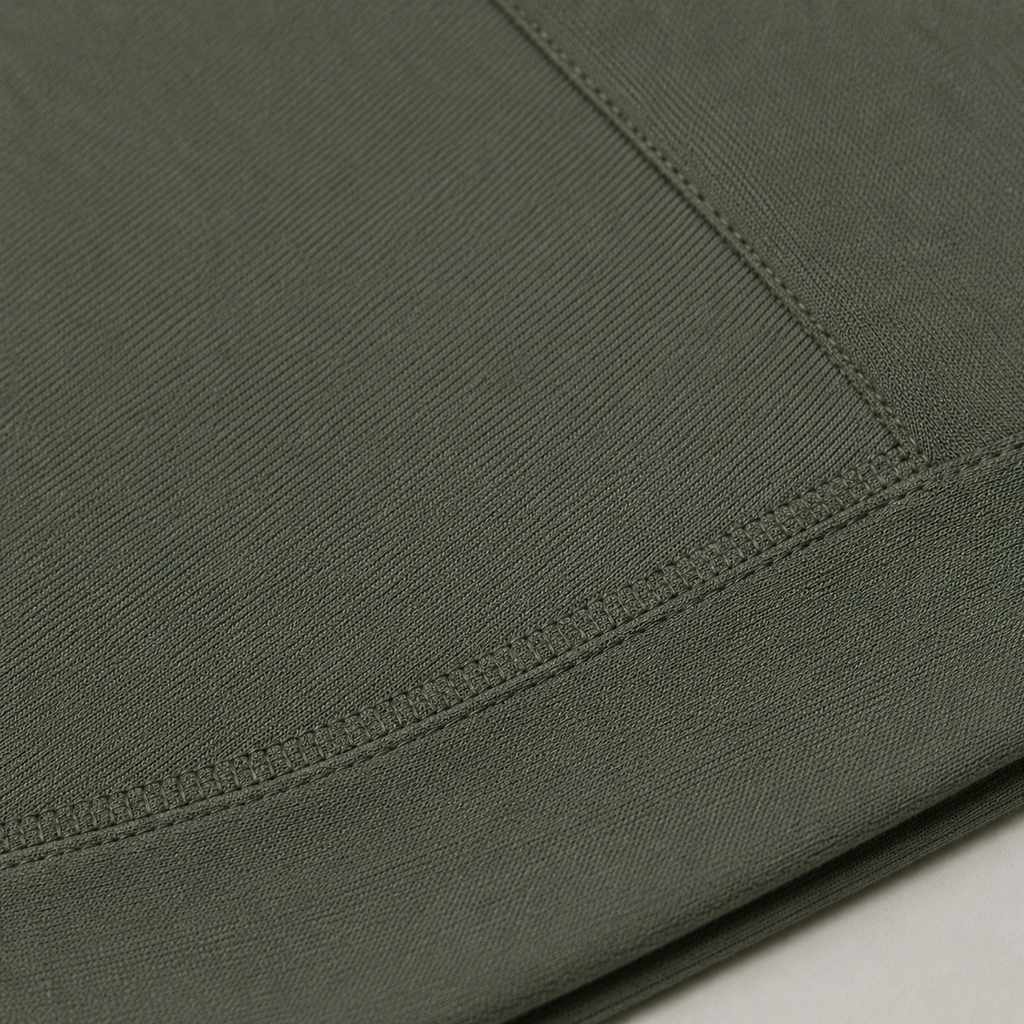 Close-up of the olive green Fitfigura Motion Bra – Sculpt Form fabric showing the seam detail and smooth performance texture.