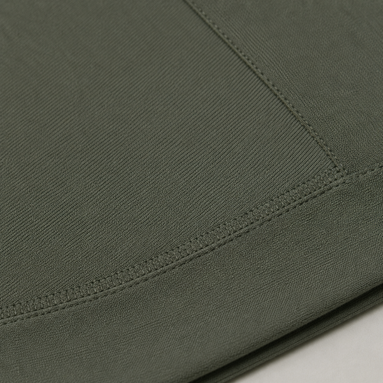 Close-up of the olive green Fitfigura Motion Bra – Sculpt Form fabric showing the seam detail and smooth performance texture.