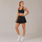 Form Black Front View
Model wearing the Fitfigura Motion Skirt – Flow Court Form in black with a matching black crop top and white sneakers, shown from the front.