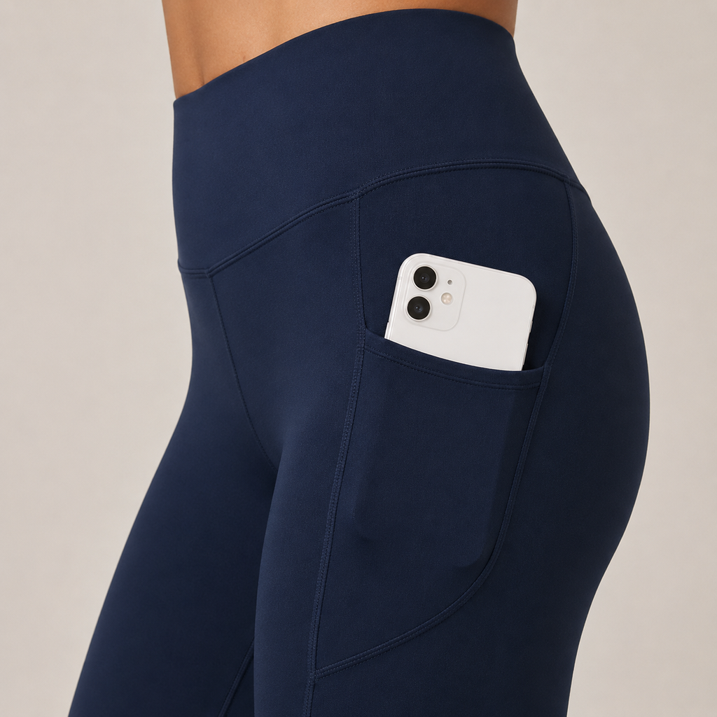 Close-up side view of the navy blue Fitfigura Pocket Legging showing the utility pocket with a phone.