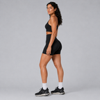 Side view of the black Fitfigura Pocket Short – Utility Performance Form, showing the fitted high-waist design and athletic short length.