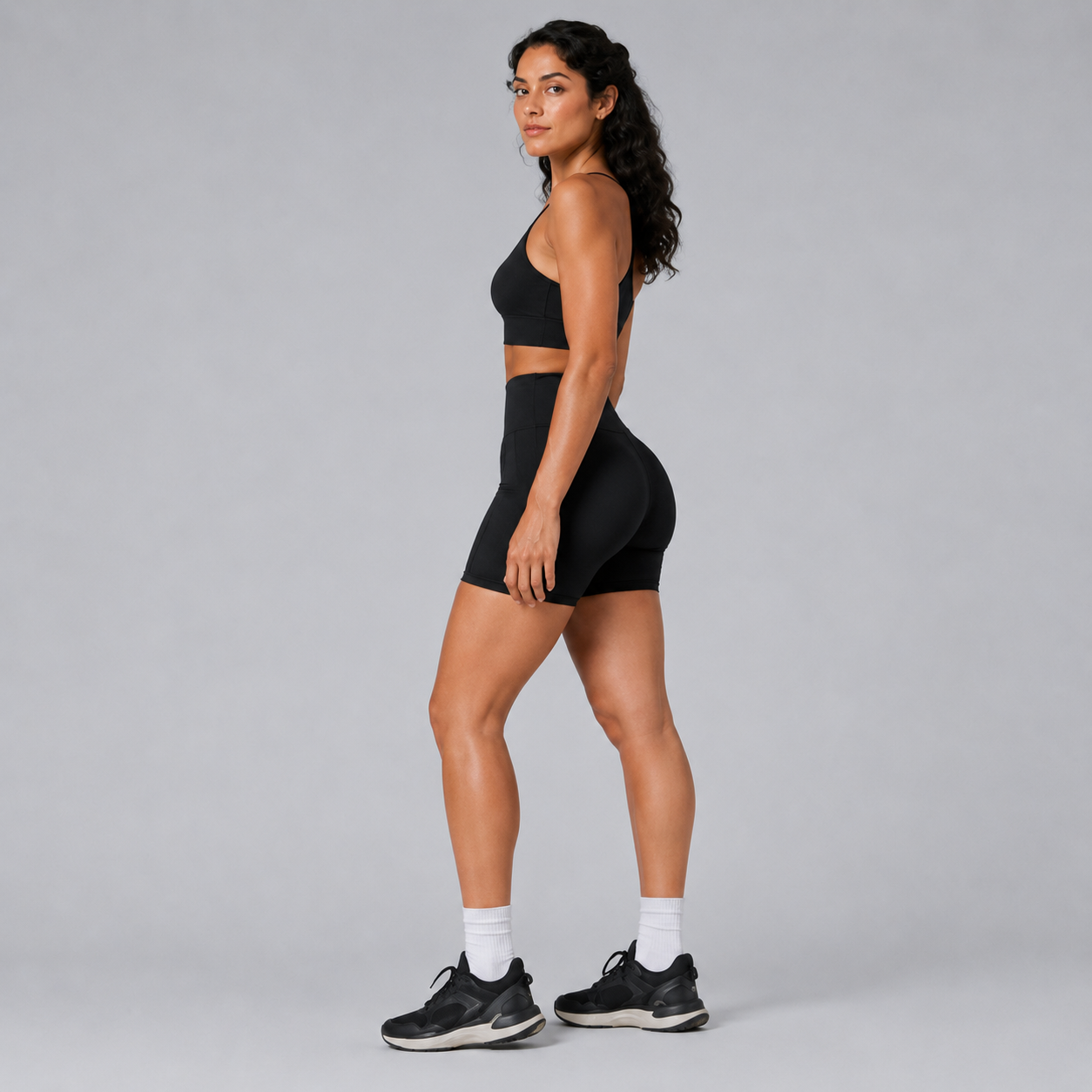Side view of the black Fitfigura Pocket Short – Utility Performance Form, showing the fitted high-waist design and athletic short length.