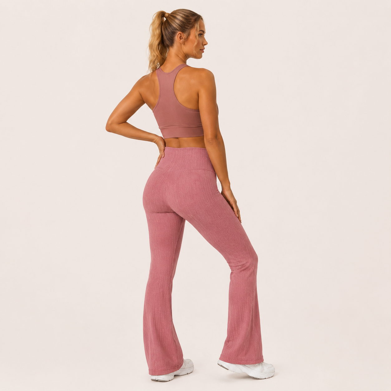 Three-quarter rear angle of the dusty pink Fitfigura Rib Knit Flare Pant – Textured Luxe Form, highlighting the contour fit and textured knit finish.