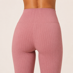 Close-up of the dusty pink Fitfigura Rib Knit Flare Pant – Textured Luxe Form showing the ribbed texture, waistband, and fitted upper silhouette.