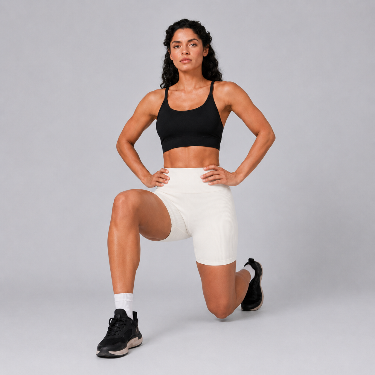 Model kneeling in the Fitfigura Rib Short – Soft Sculpt Form in white, highlighting the supportive fit and soft sculpting silhouette.