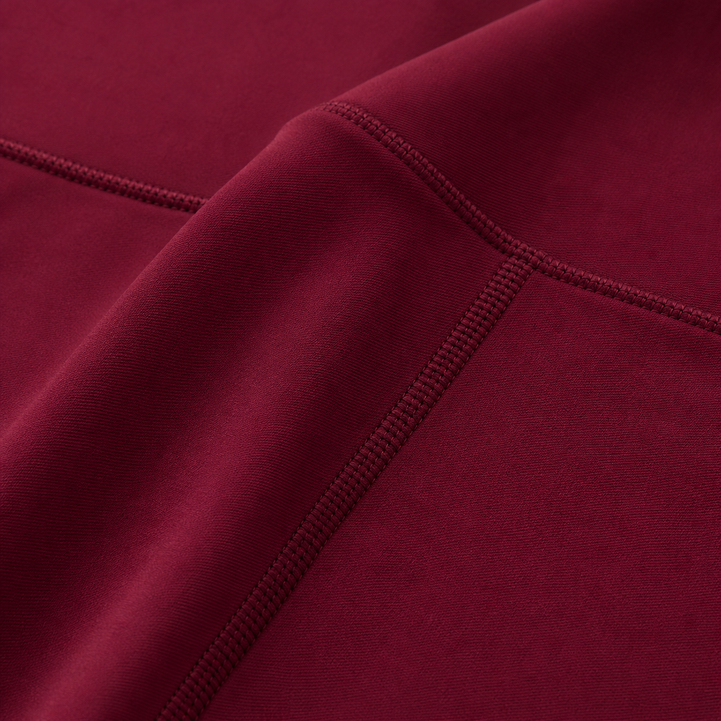 Close-up of the burgundy fabric texture and seam detail used in the Fitfigura Sculpt Butterlift Leggings.