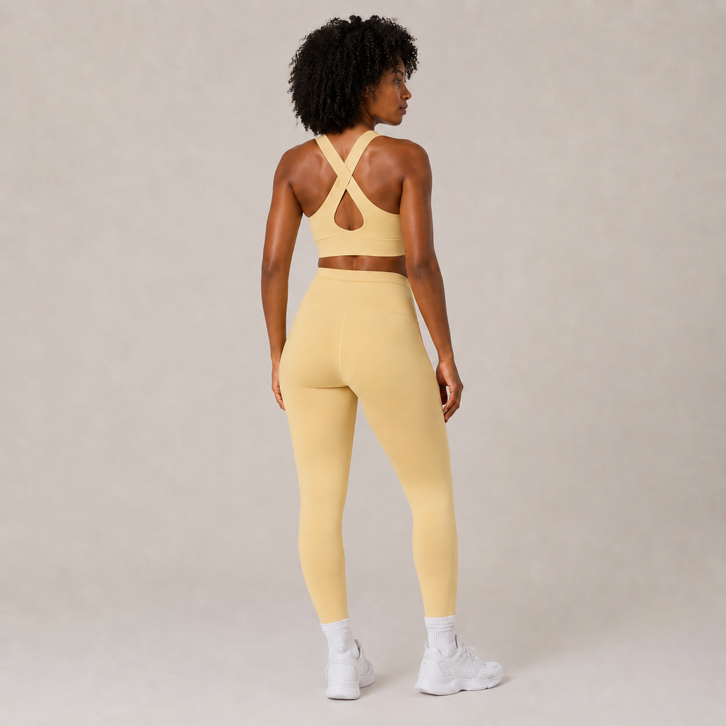 Rear-angle view of the butter yellow Fitfigura Sculpt Set – Seamless Form, showing the strappy back sports bra and fitted leggings.
