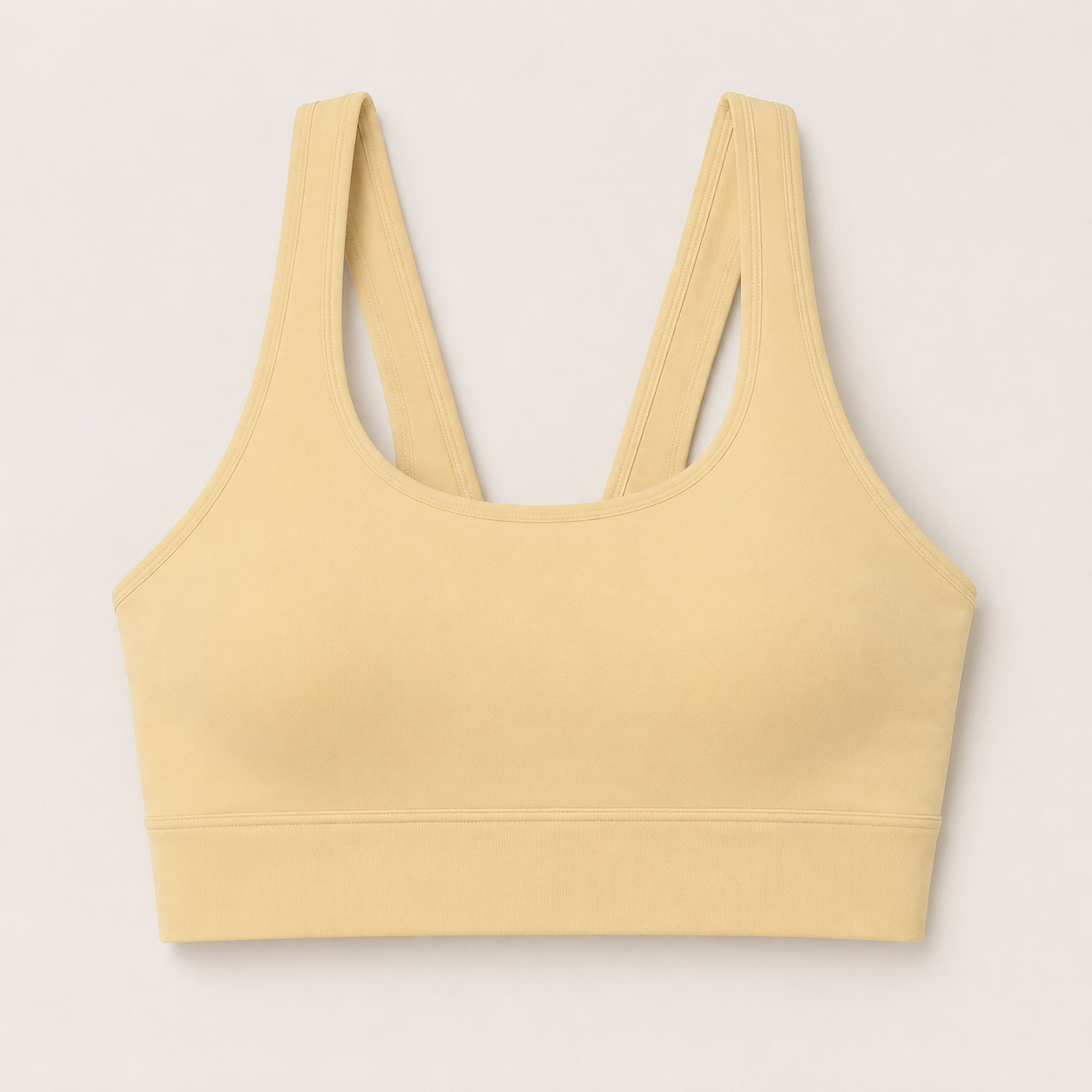 Flat lay front view of the Fitfigura Sculpt Set – Seamless Form sports bra in butter yellow, showing the scoop neckline and wide straps.
