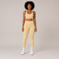 Model wearing the Fitfigura Sculpt Set – Seamless Form in butter yellow, featuring a seamless sports bra and matching high-waisted leggings, shown from the front.