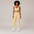 Model wearing the Fitfigura Sculpt Set – Seamless Form in butter yellow, featuring a seamless sports bra and matching high-waisted leggings, shown from the front.