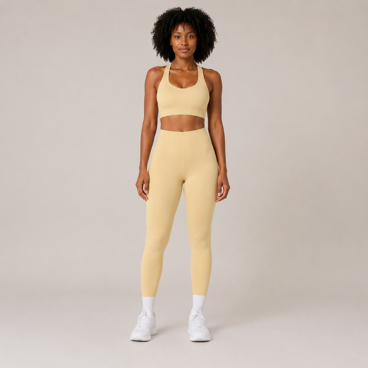 Model wearing the Fitfigura Sculpt Set – Seamless Form in butter yellow, featuring a seamless sports bra and matching high-waisted leggings, shown from the front.