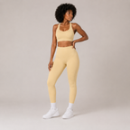 Model posing in the butter yellow Fitfigura Sculpt Set – Seamless Form, showing the coordinated sports bra and leggings silhouette.