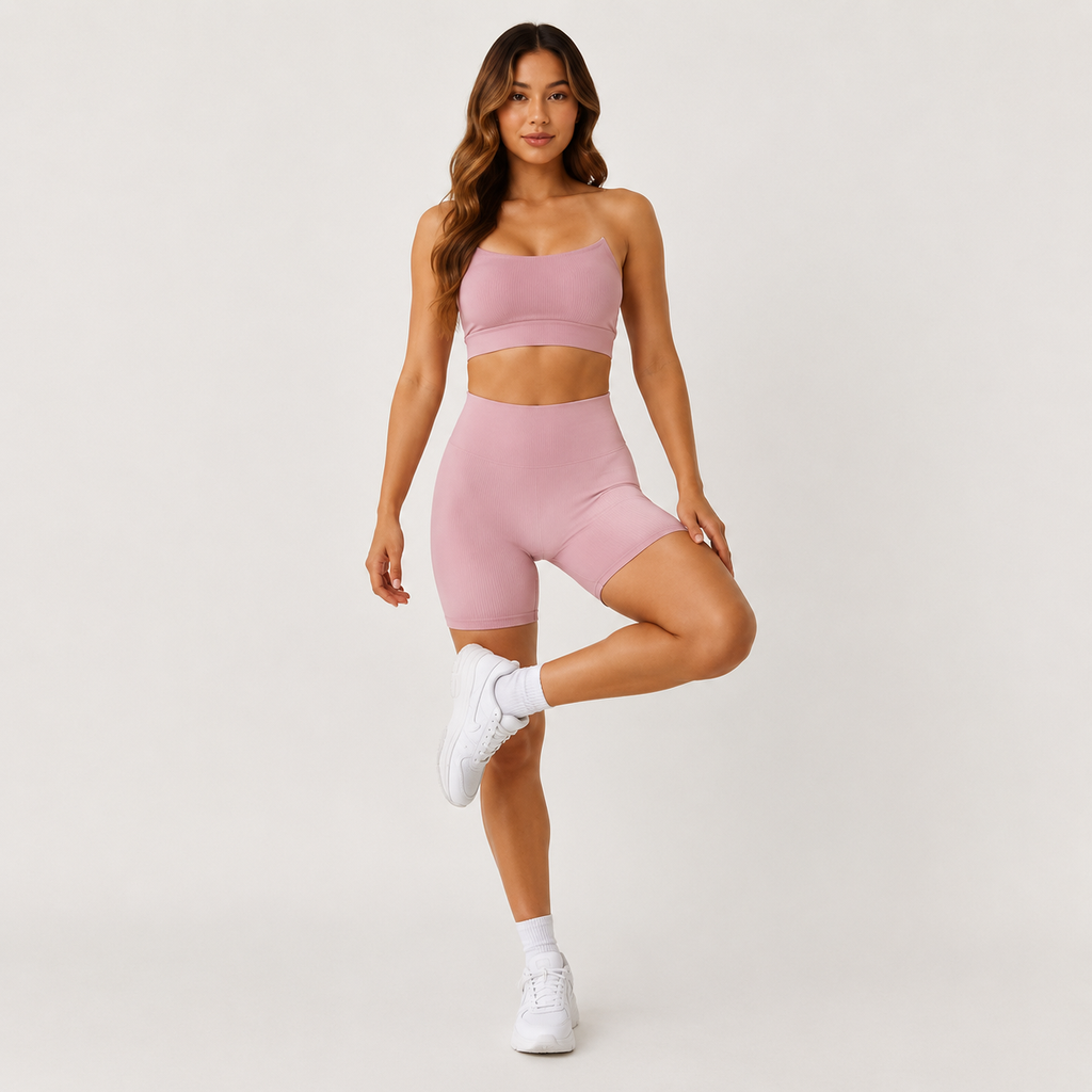 Model posing in the Fitfigura Sculpt Short 6” – Performance Sculpt Form in light pink with one leg raised, showing the flexible activewear fit.