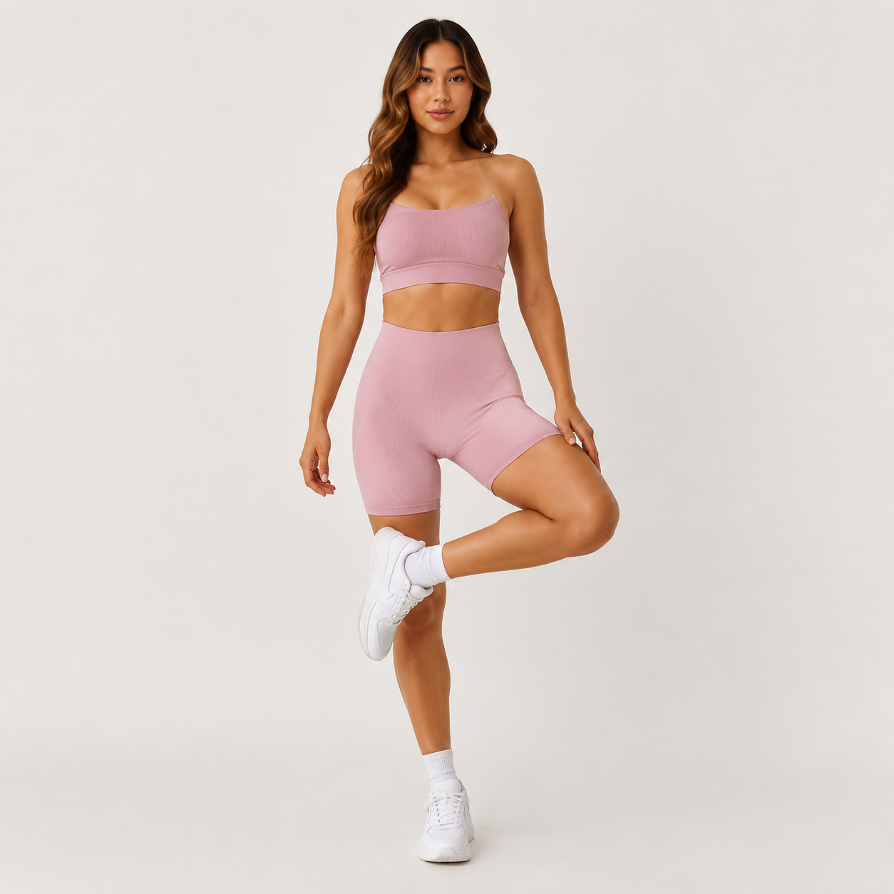 Model posing in the Fitfigura Sculpt Short 6” – Performance Sculpt Form in light pink with one leg raised, showing the flexible activewear fit.