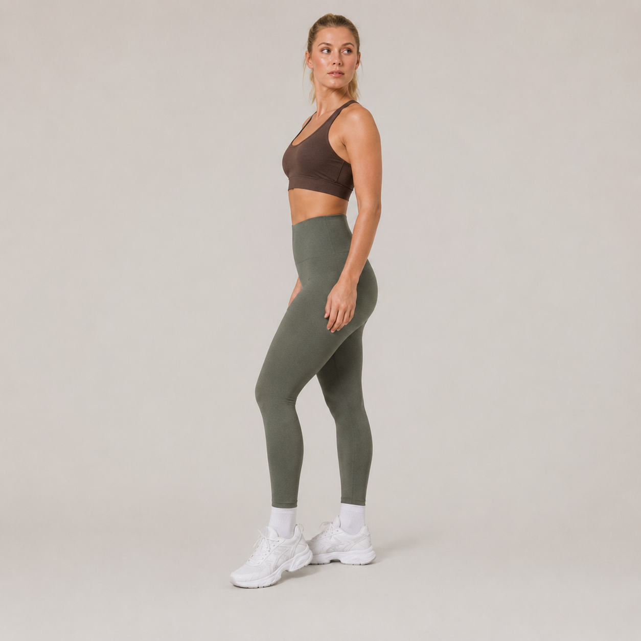 Angled studio view of the Fitfigura Seamless Legging in olive green, highlighting the smooth seamless fit through the hips and legs.