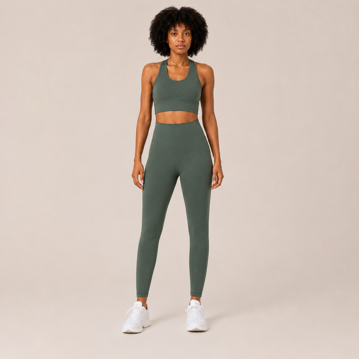 Model wearing the Fitfigura Seamless Set – Performance Sculpt Form in sage green, featuring a sleeveless crop top and matching high-waisted leggings, shown from the front.