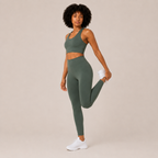 Model wearing the sage green Fitfigura Seamless Set – Performance Sculpt Form in a leg-lift pose, highlighting the stretch and movement-ready design.