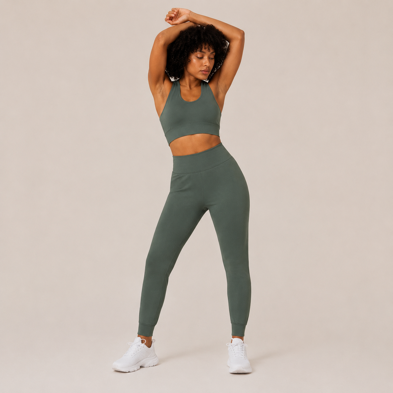 Model posing in the sage green Fitfigura Seamless Set – Performance Sculpt Form with arms raised, highlighting the flexible sculpting fit.